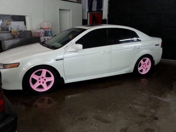 Car with the pink to orange glow in the dark wheels in the light.